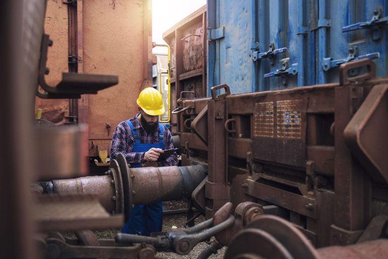 railroad-worker-checking-cargo-containers-freight-train-station